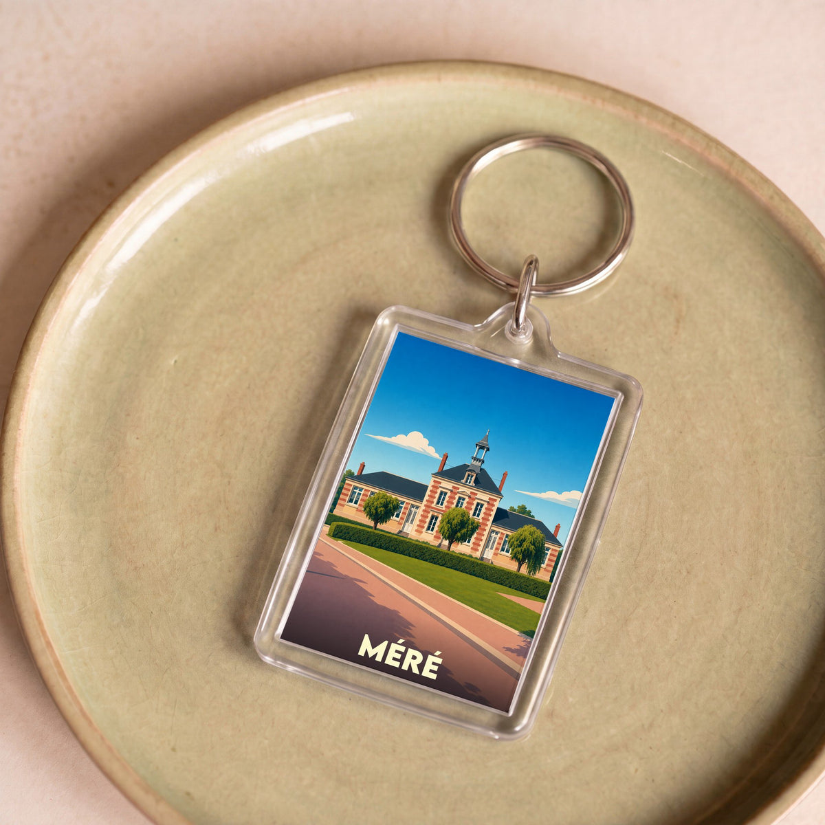 Porte-clés souvenir de la ville de Méré avec une illustration stylisée.