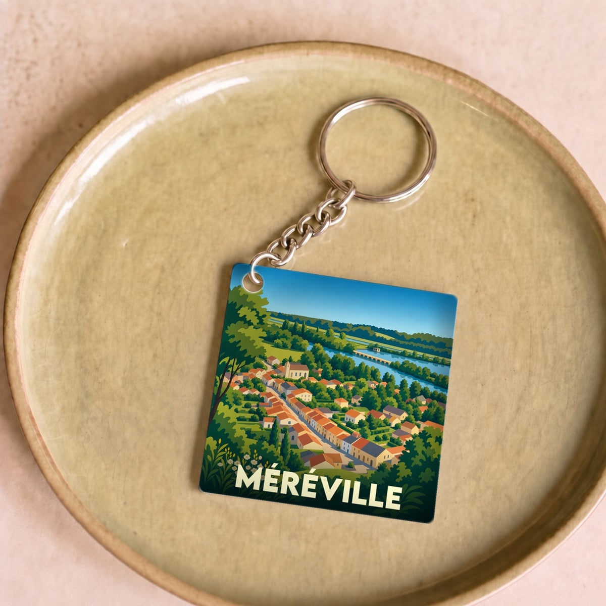 Porte-clés souvenir de la ville de Méréville avec une illustration stylisée.
