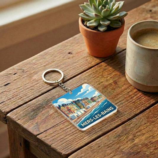 Porte-clés souvenir de la ville de Mers-les-Bains avec une illustration stylisée de son front de mer coloré.