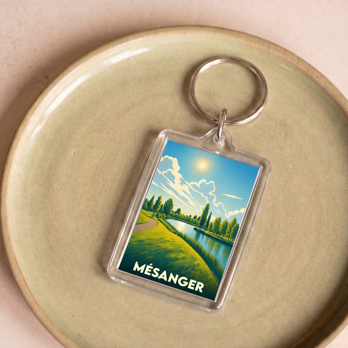 Porte-clés souvenir de la ville de Mésanger avec une illustration stylisée de paysage.