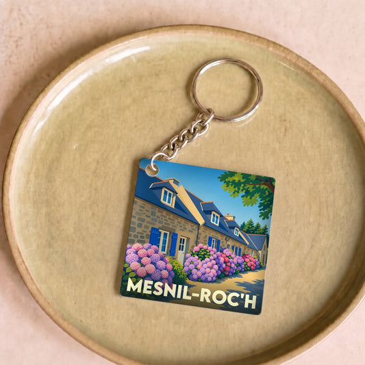 Porte-clés souvenir de la commune de Mesnil-Roc'h avec une illustration stylisée de maisons bretonnes et d'hortensias.