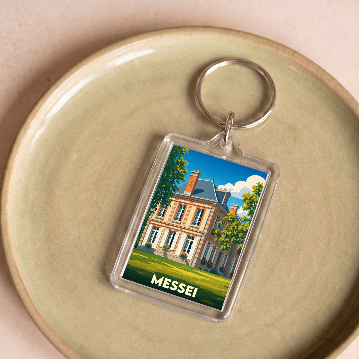 Porte-clés souvenir de la ville de Messei avec une illustration stylisée de son château.