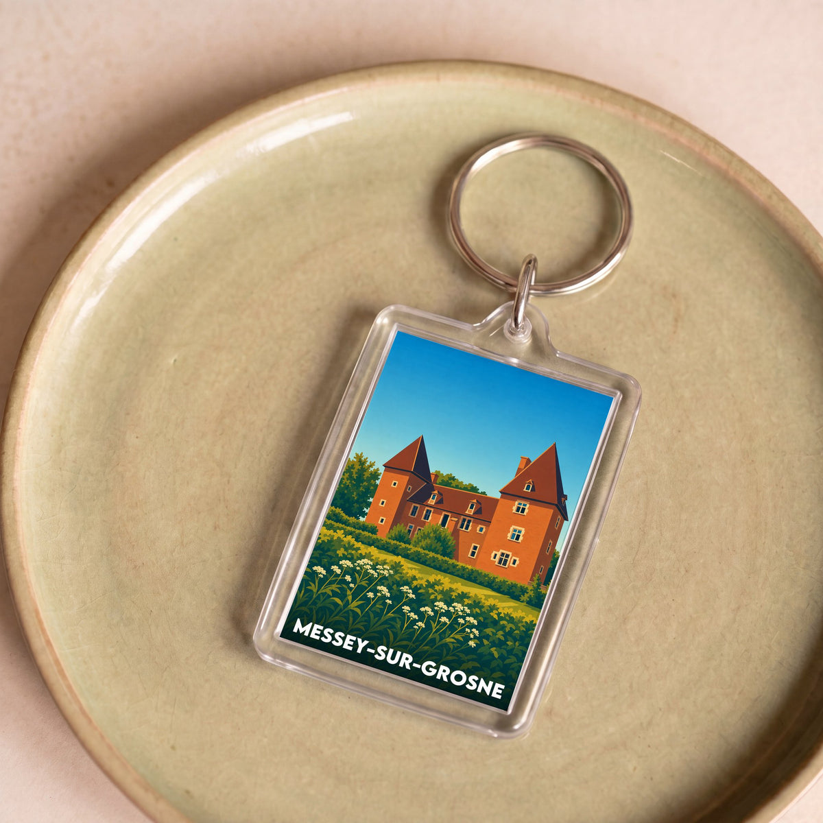 Porte-clés souvenir de la ville de Messey-sur-Grosne avec une illustration stylisée.