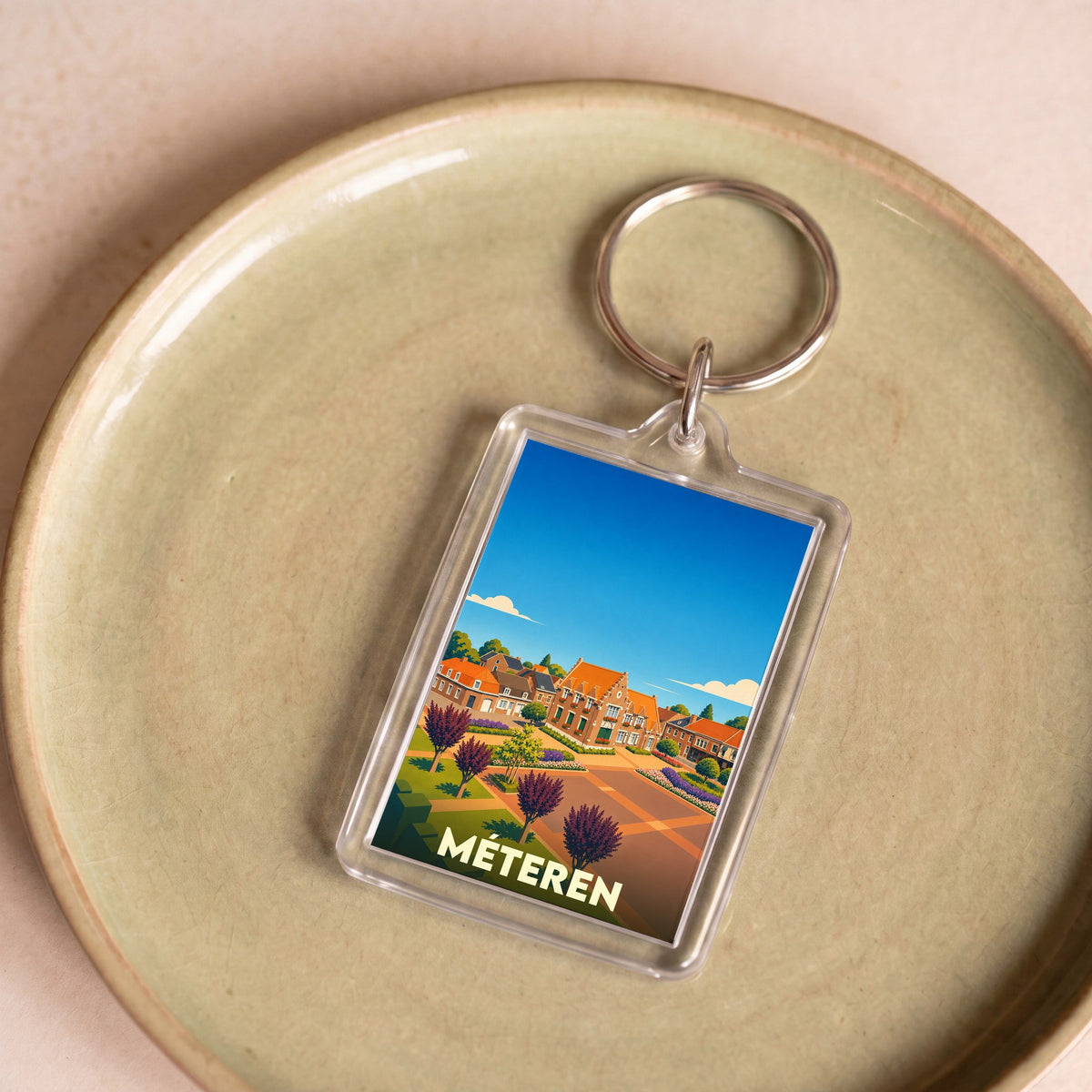 Porte-clés souvenir de la ville de Méteren avec une illustration stylisée.