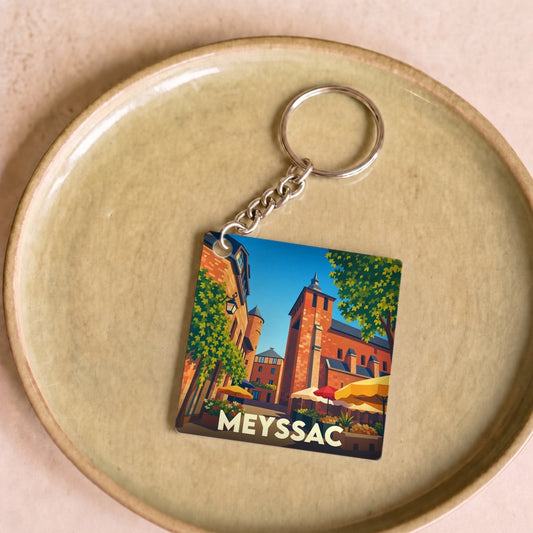 Porte-clés souvenir de la ville de Meyssac avec une illustration stylisée.