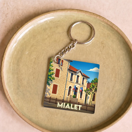 Porte-clés souvenir de la ville de Mialet avec une illustration stylisée de sa mairie.