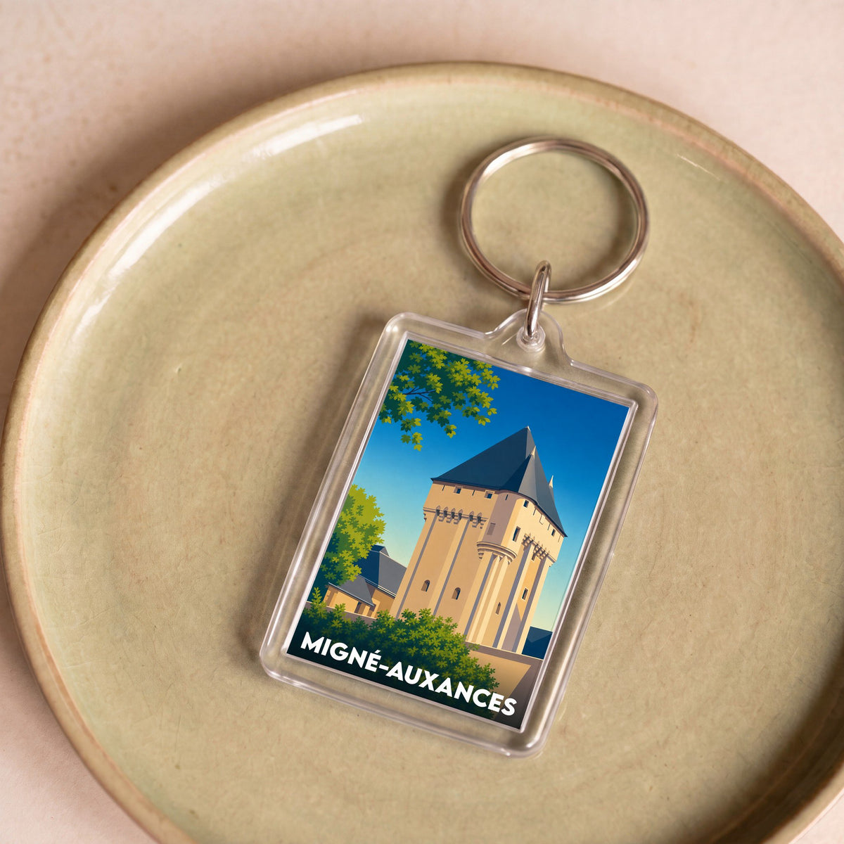 Porte-clés souvenir de la ville de Migné-Auxances avec une illustration stylisée de son patrimoine.