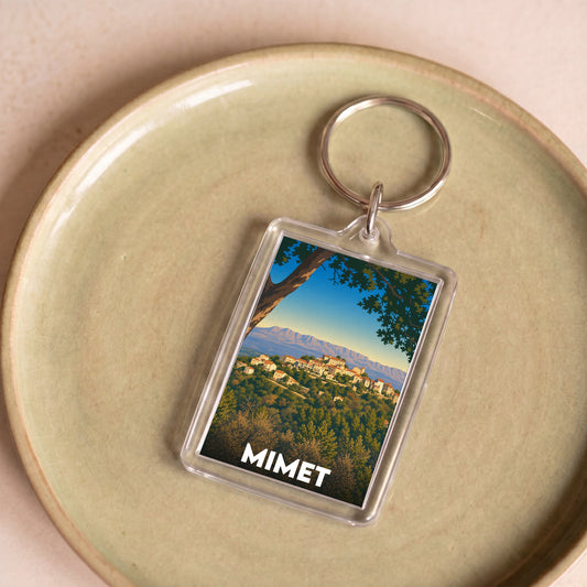 Porte-clés souvenir de la ville de Mimet avec une illustration stylisée de son paysage.