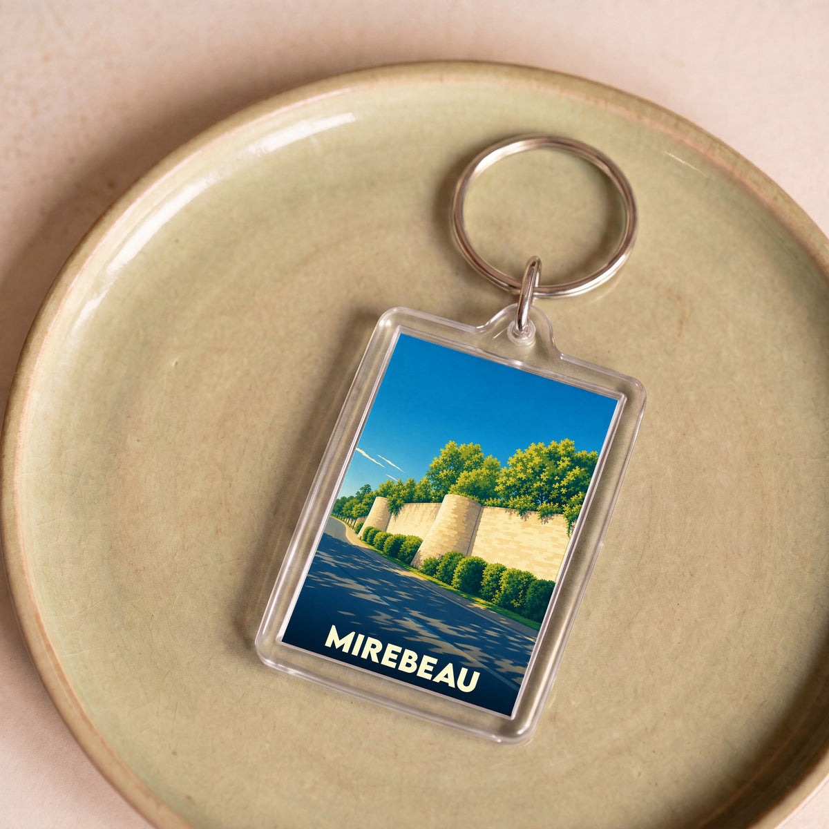 Porte-clés souvenir de la ville de Mirebeau avec une illustration stylisée de ses remparts.
