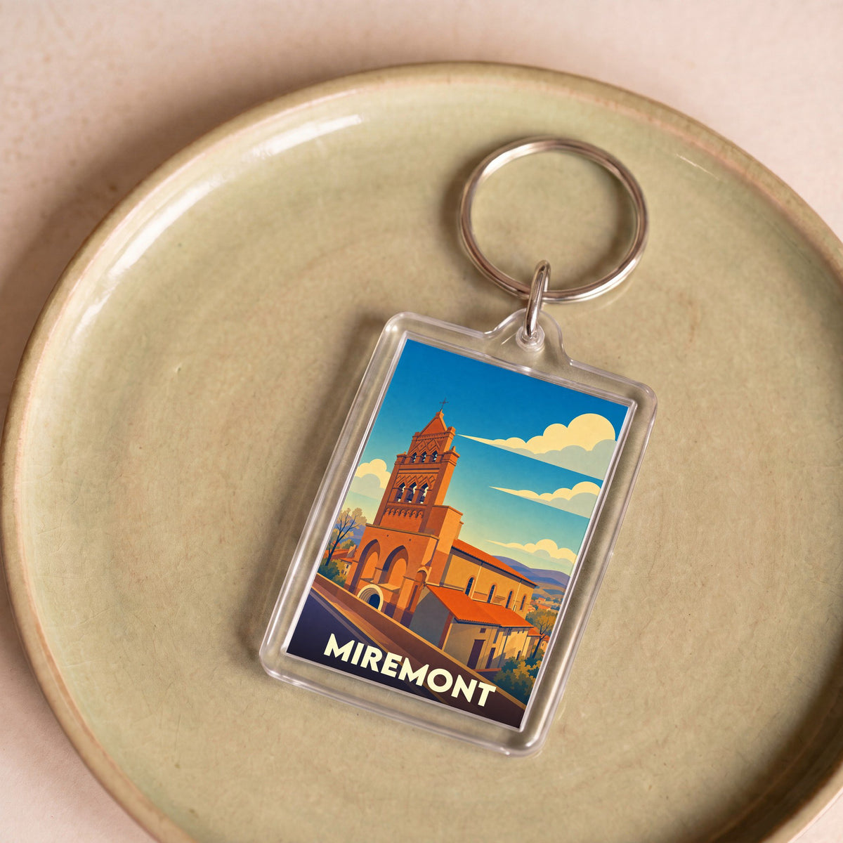 Porte-clés souvenir de la ville de Miremont avec une illustration stylisée de son église.