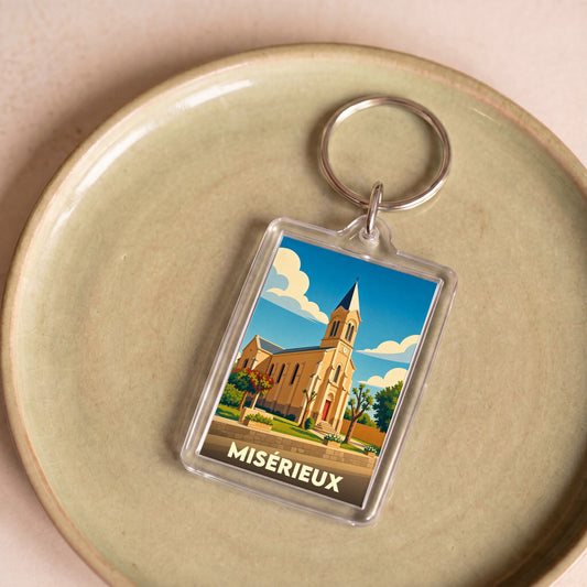 Porte-clés souvenir de la ville de Misérieux avec une illustration stylisée de son église.