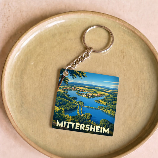 Porte-clés souvenir de la ville de Mittersheim avec une illustration stylisée de son paysage lacustre.
