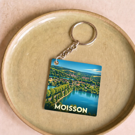 Porte-clés souvenir de la ville de Moisson avec une illustration paysagère stylisée.