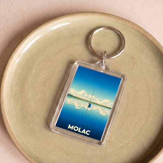 Porte-clés souvenir de la ville de Molac avec une illustration stylisée d'un voilier sur l'eau.