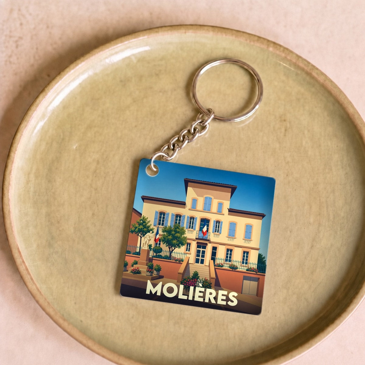 Porte-clés souvenir de la ville de Molières avec une illustration stylisée de sa mairie.