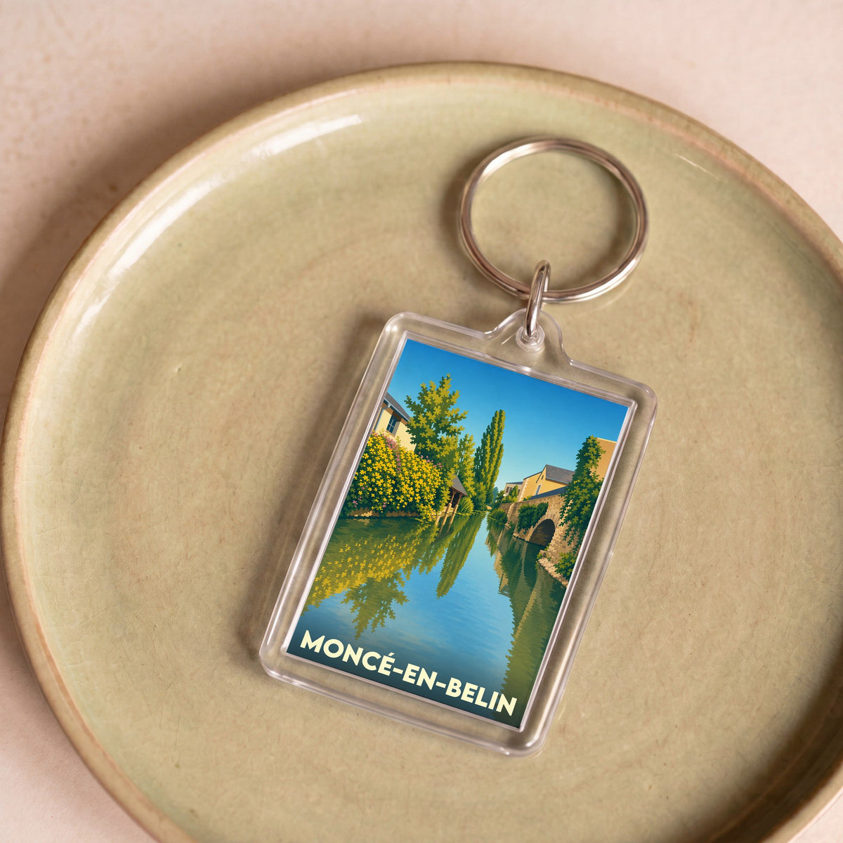 Porte-clés souvenir de la ville de Moncé-en-Belin avec une illustration stylisée.