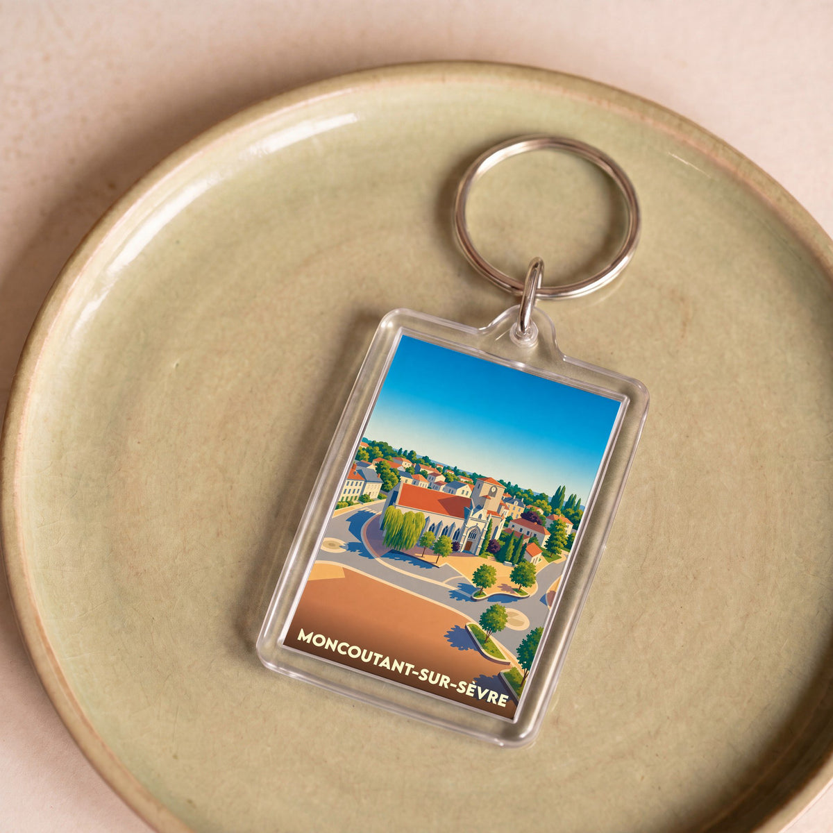 Porte-clés souvenir de la ville de Moncoutant-sur-Sèvre avec une illustration stylisée.