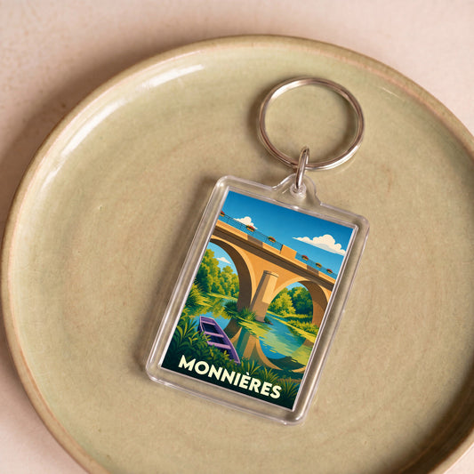 Porte-clés souvenir de la ville de Monnières avec une illustration stylisée d'un pont et d'une barque.