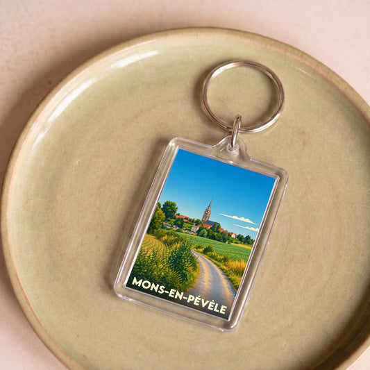 Porte-clés souvenir de la ville de Mons-en-Pévèle avec une illustration stylisée.