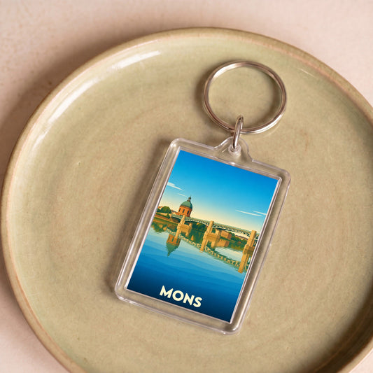 Porte-clés souvenir de la ville de Mons avec une illustration stylisée.