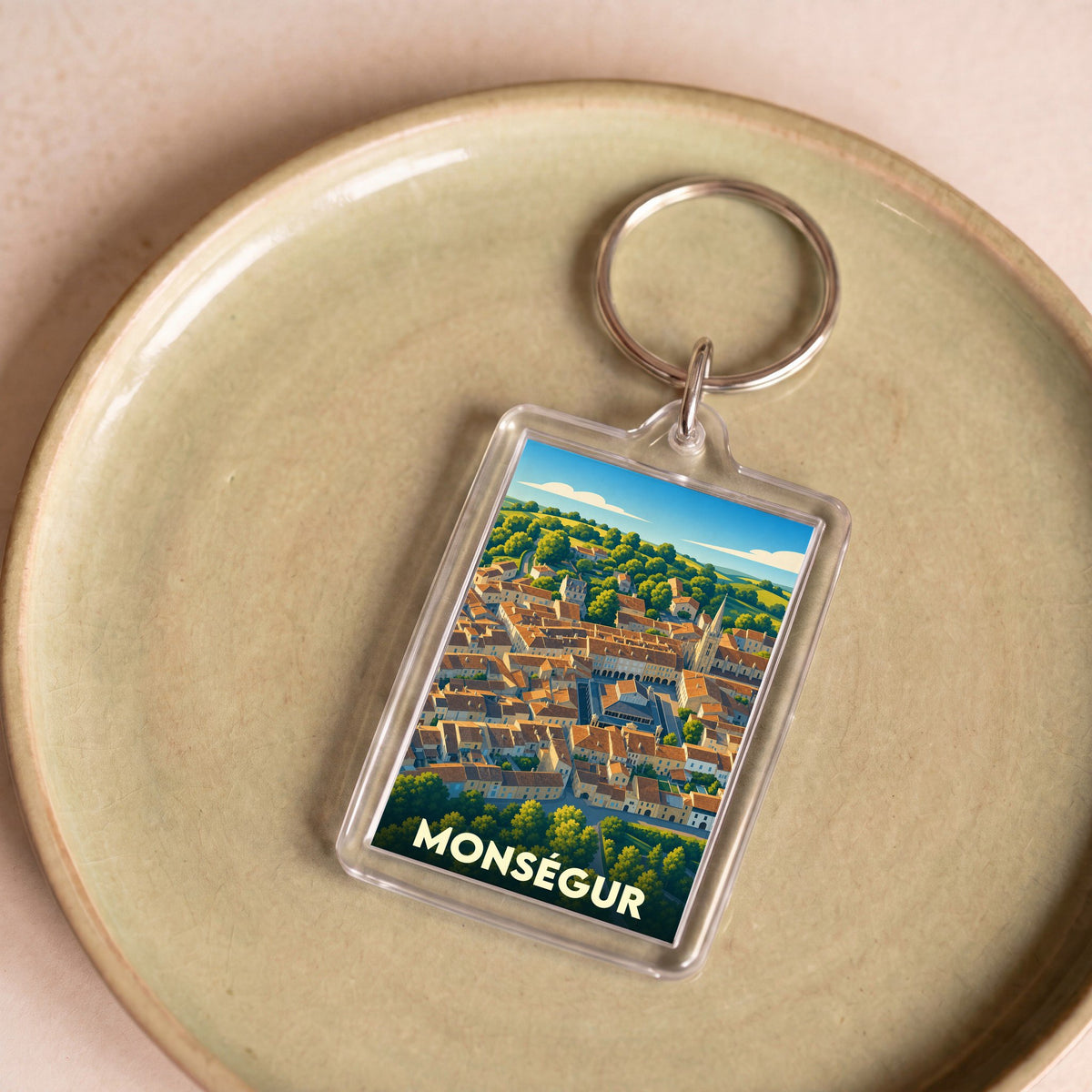 Porte-clés souvenir de la ville de Monségur avec une illustration stylisée.