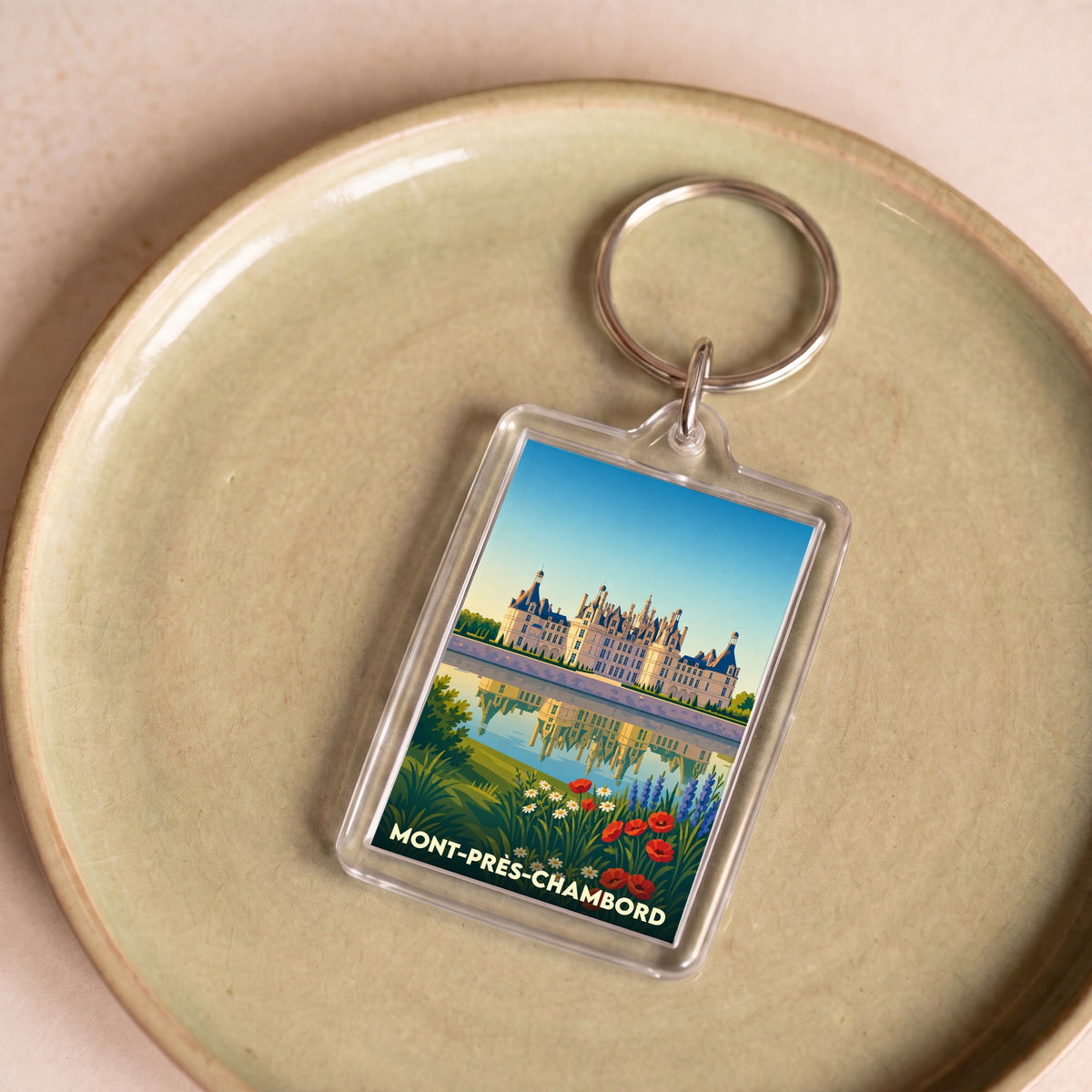 Porte-clés souvenir de la ville de Mont-près-Chambord avec une illustration stylisée du château.