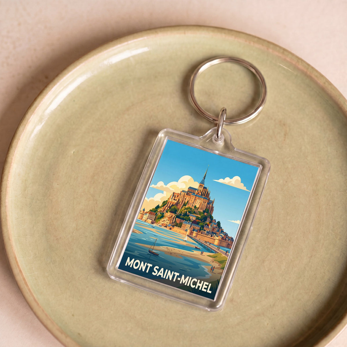 Porte-clés souvenir de la ville du Mont Saint-Michel avec une illustration stylisée.