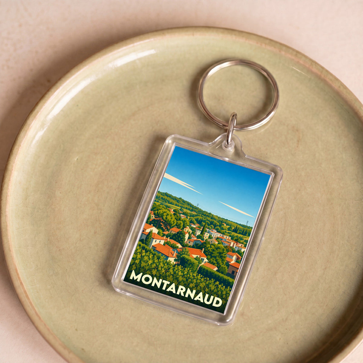 Porte-clés souvenir de la ville de Montarnaud avec une illustration stylisée de ses paysages.
