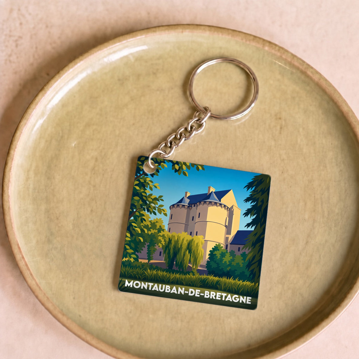 Porte-clés souvenir de la ville de Montauban-de-Bretagne avec une illustration stylisée d'un château.