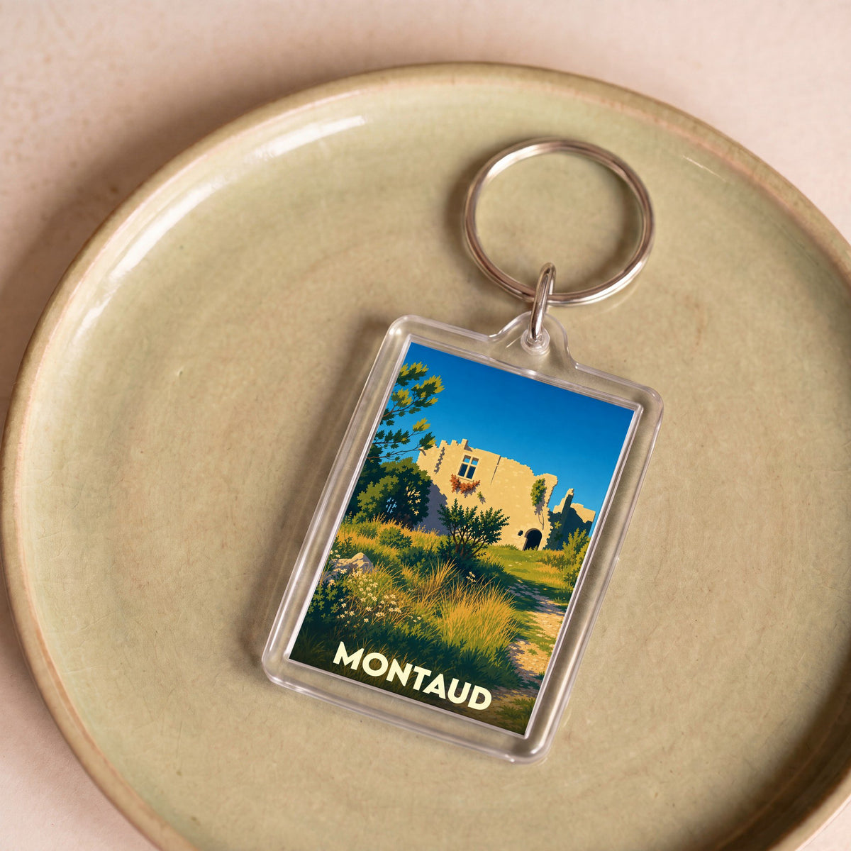 Porte-clés souvenir de la ville de Montaud avec une illustration stylisée.