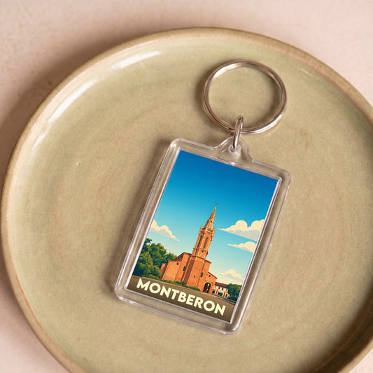 Porte-clés souvenir de la ville de Montberon avec une illustration stylisée de son église.