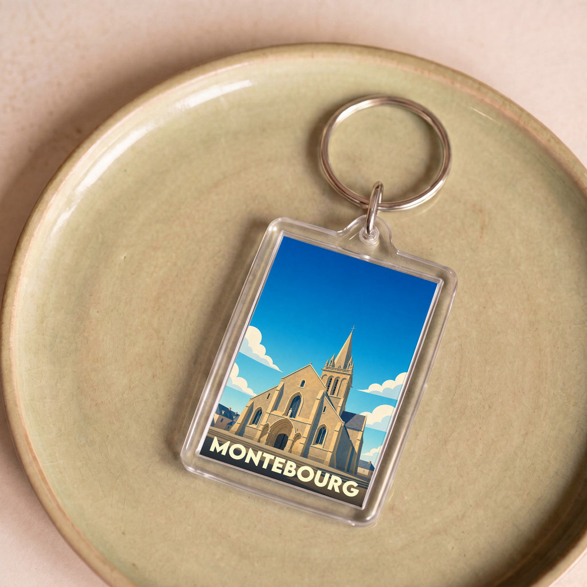 Porte-clés souvenir de la ville de Montebourg avec une illustration stylisée de son église.