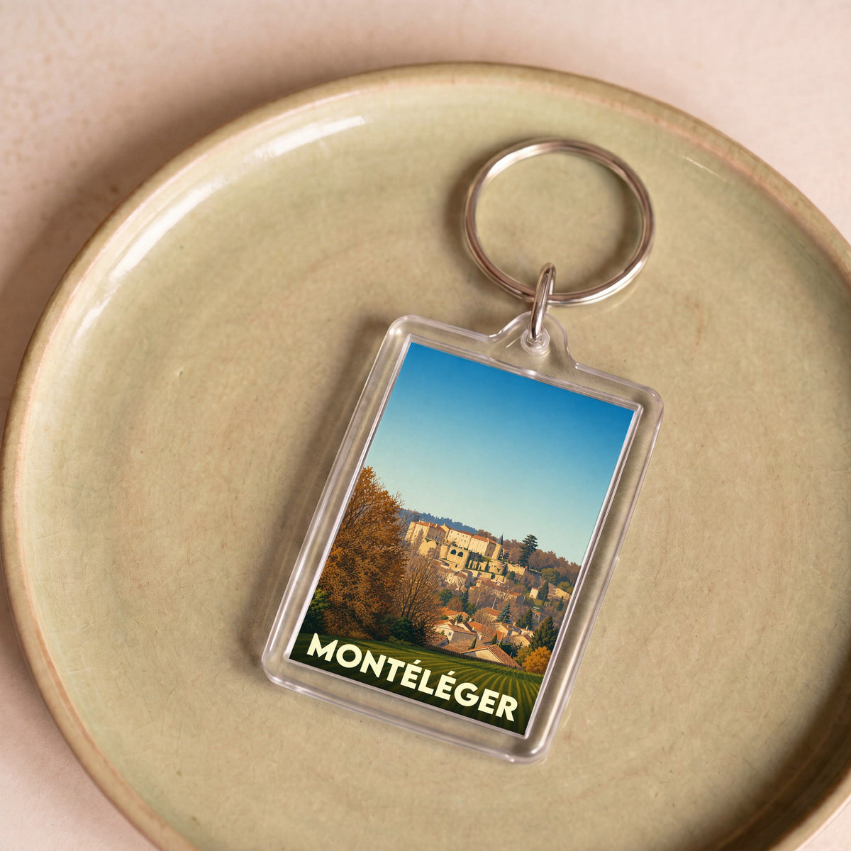 Porte-clés souvenir de la ville de Montéléger avec une illustration stylisée de son paysage urbain.