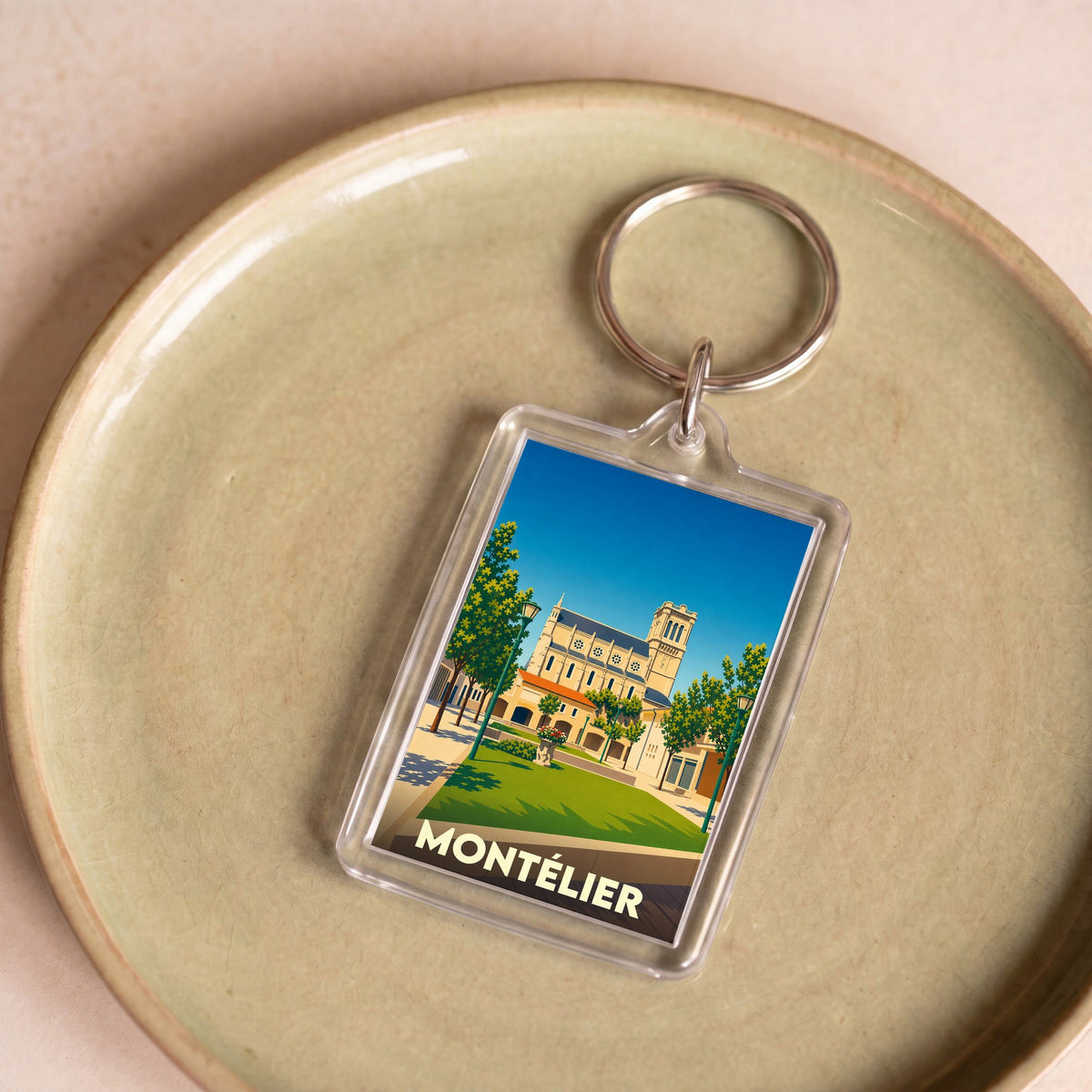 Porte-clés souvenir de la ville de Montélier avec une illustration stylisée.