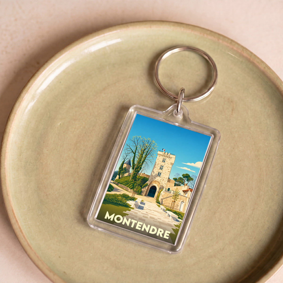 Porte-clés souvenir de la ville de Montendre avec une illustration stylisée de son château.