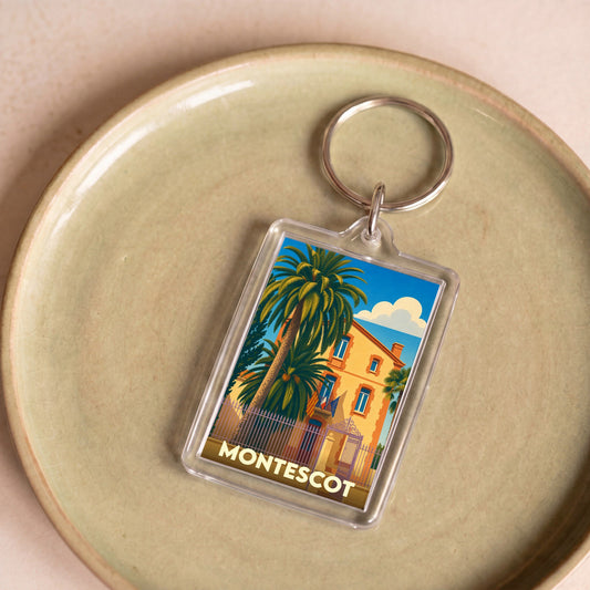 Porte-clés souvenir de la ville de Montescot avec une illustration stylisée d'une bâtisse et de palmiers.