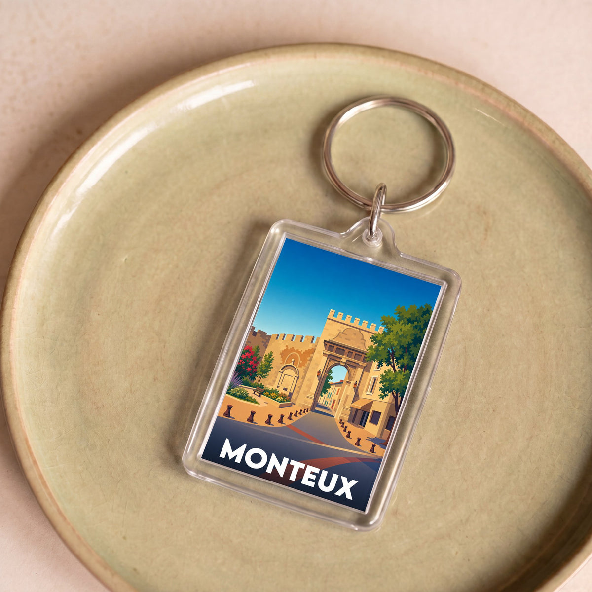 Porte-clés souvenir de la ville de Monteux avec une illustration stylisée.