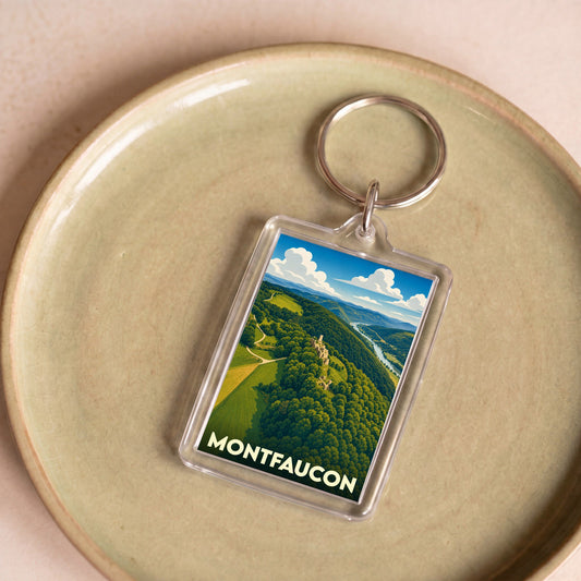 Porte-clés souvenir de la ville de Montfaucon illustrant un paysage de collines verdoyantes surplombant un cours d'eau.