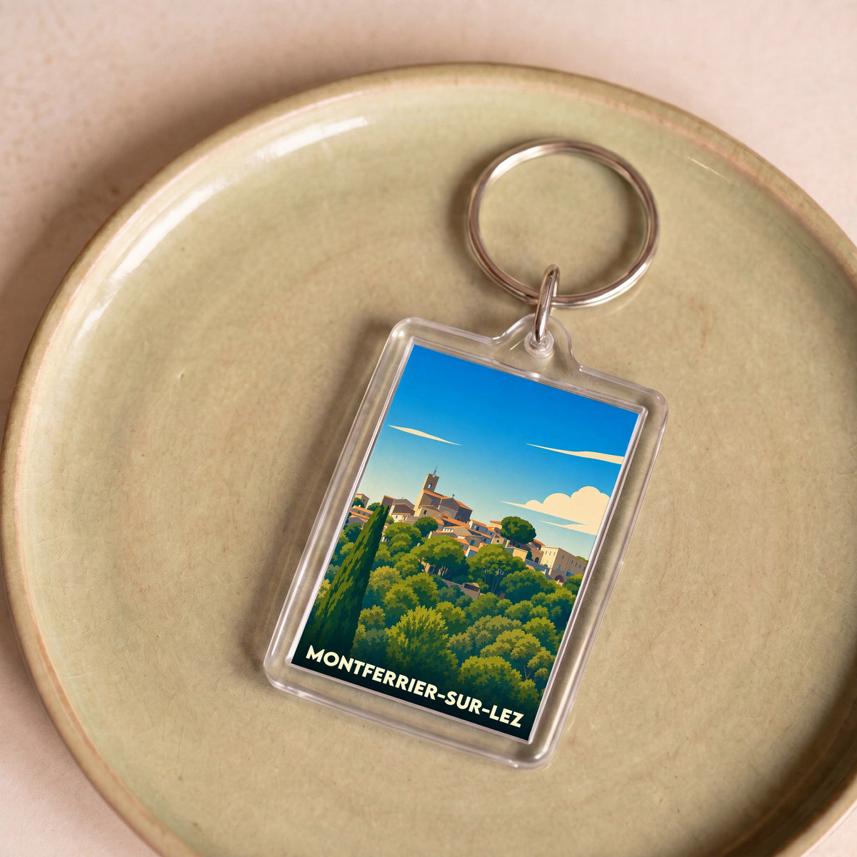 Porte-clés souvenir de la ville de Montferrier-sur-Lez avec une illustration stylisée.