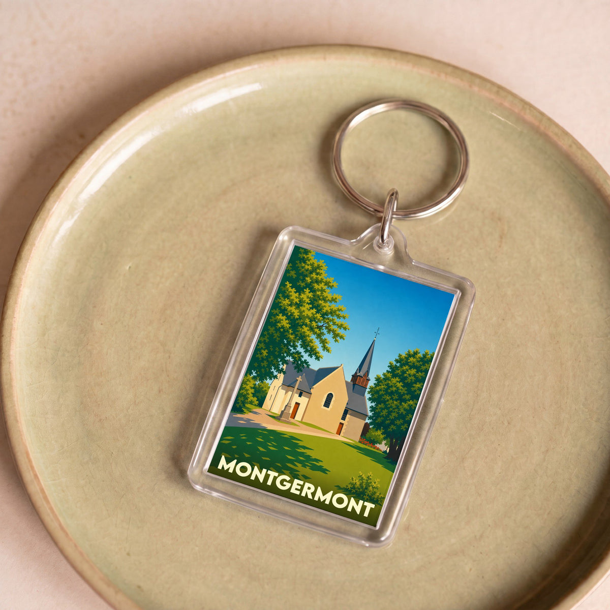 Porte-clés souvenir de la ville de Montgermont avec une illustration stylisée de son église.