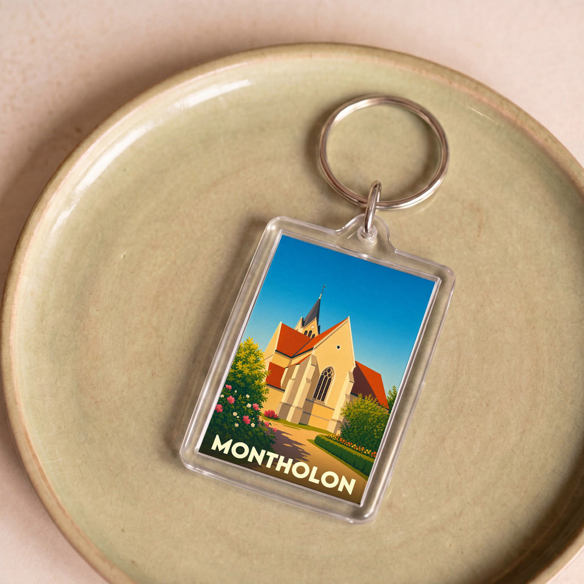 Porte-clés souvenir de la commune de Montholon avec une illustration stylisée de son église.