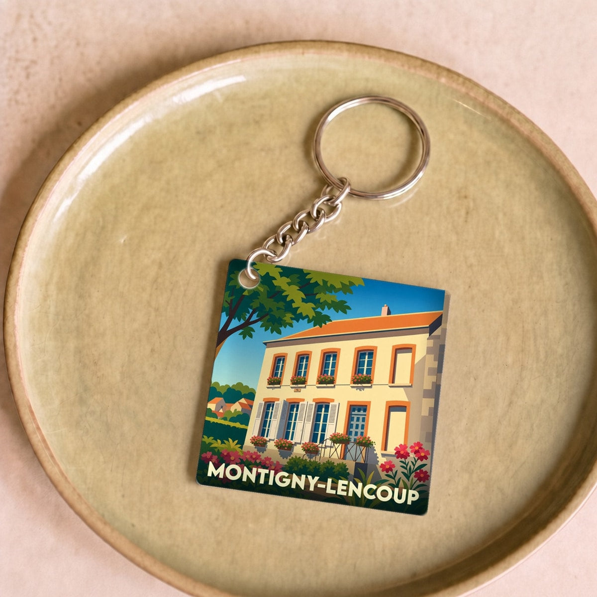 Porte-clés souvenir de la ville de Montigny-Lencoup avec une illustration stylisée.