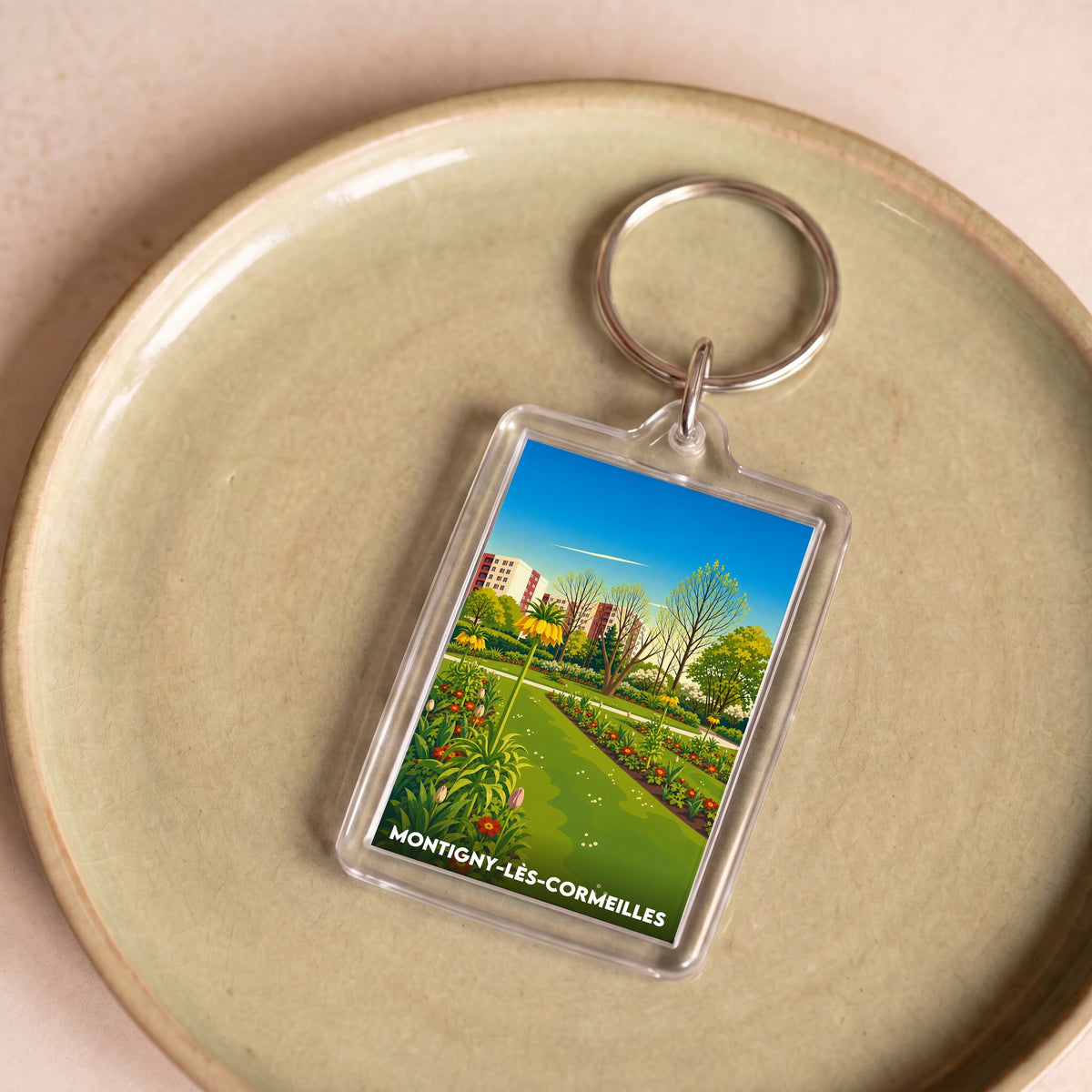 Porte-clés souvenir de la ville de Montigny-lès-Cormeilles avec une illustration stylisée.