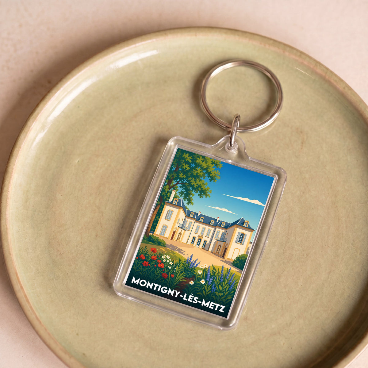 Porte-clés souvenir de la ville de Montigny-lès-Metz avec une illustration stylisée.