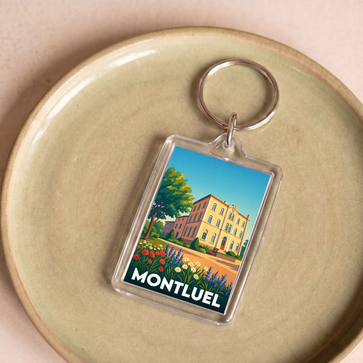 Porte-clés souvenir de la ville de Montluel avec une illustration colorée et stylisée.