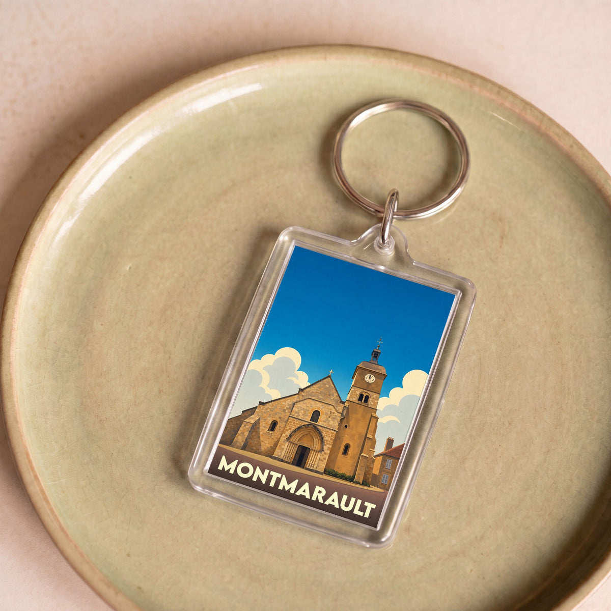 Porte-clés souvenir de la ville de Montmarault avec une illustration stylisée de son église.
