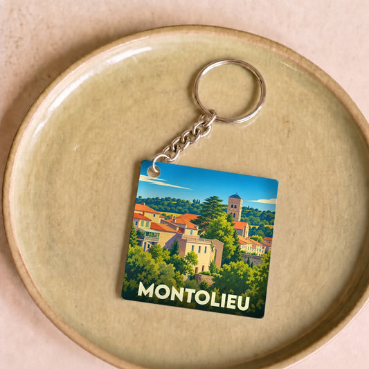 Porte-clés souvenir de la ville de Montolieu avec une illustration stylisée du village.