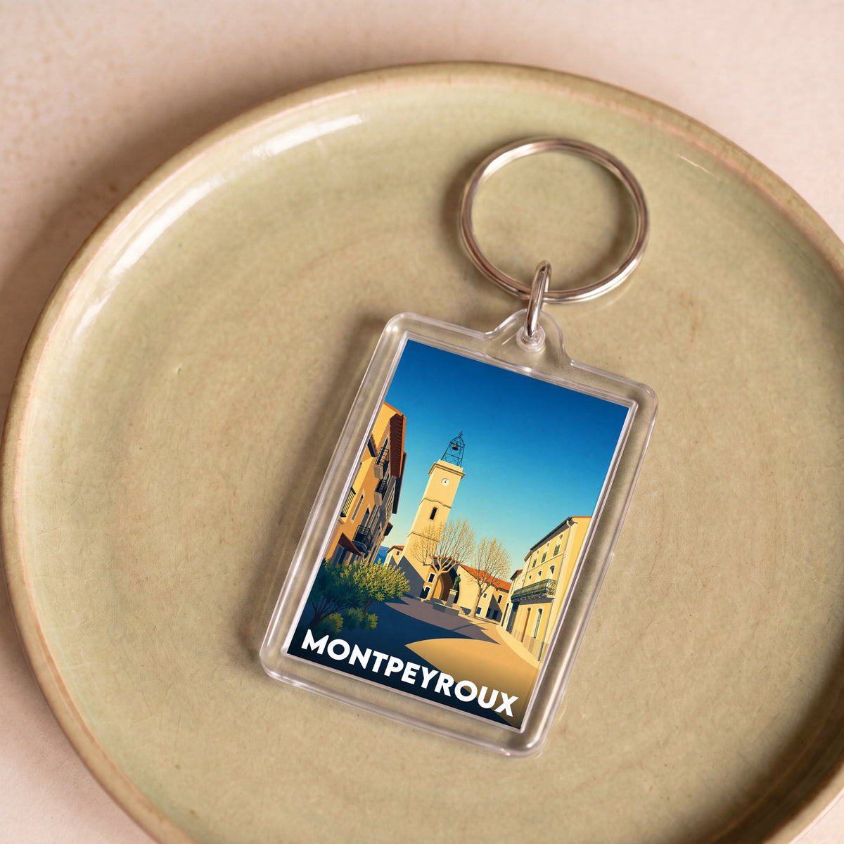 Porte-clés souvenir de la ville de Montpeyroux avec une illustration stylisée.