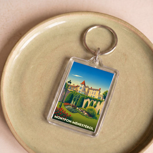 Porte-clés souvenir de la ville de Montpon-Ménestérol avec une illustration stylisée d'un domaine fleuri.