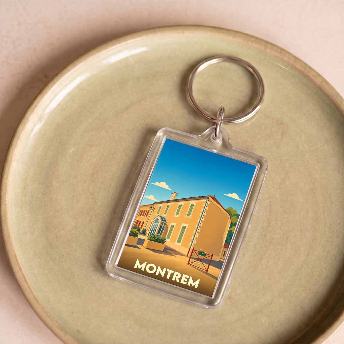 Porte-clés souvenir de la ville de Montrem avec une illustration stylisée d'un bâtiment emblématique.